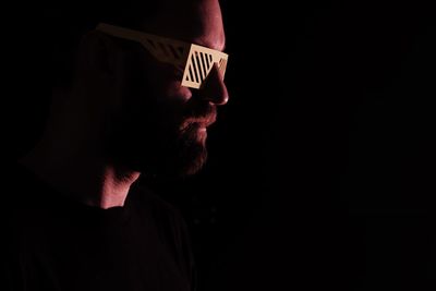 Close-up of man in 3-d glasses against black background