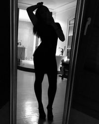 Rear view of woman standing at home