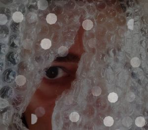 Close-up of person seen through bubble wrap