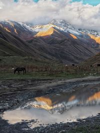 Scenic view of lake and mountains against sky