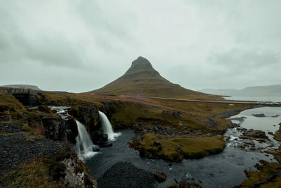 Scenic view of waterfall against sky