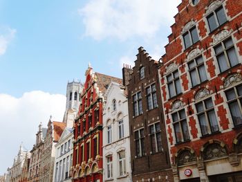 Low angle view of buildings against cloudy sky