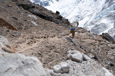 Rear view of person on rocks against mountains