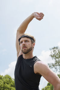 Low angle view of man looking away against sky