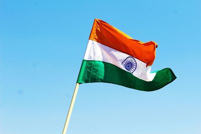 Low angle view of indian flag against clear blue sky