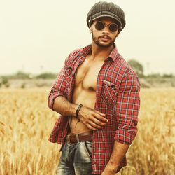 Young man wearing sunglasses while standing on field