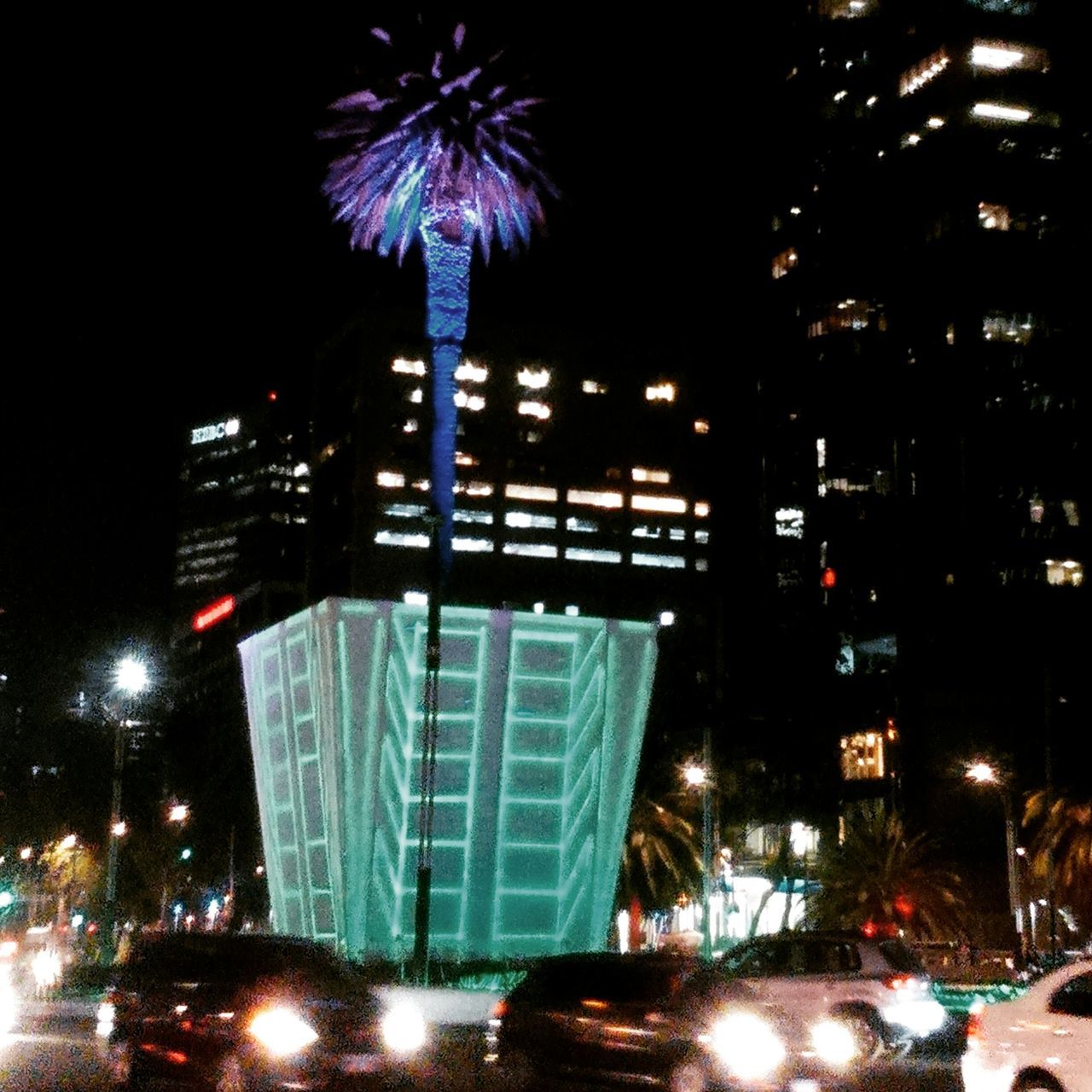 illuminated, night, building exterior, architecture, city, built structure, long exposure, skyscraper, low angle view, modern, city life, firework display, motion, sky, tall - high, street, building, lighting equipment, office building, glowing