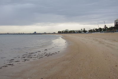 Scenic view of beach against cloudy sky