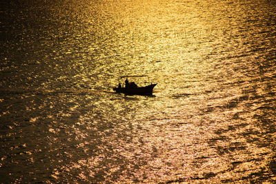 High angle view of silhouette boat in sea during sunset