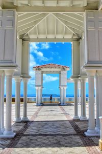 View of colonnade and buildings against sky