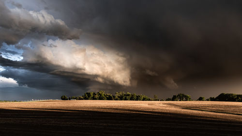 Scenic view of field against cloudy sky