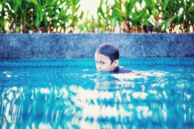 Portrait of boy swimming in pool