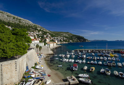 High angle view of boats moored in harbor against buildings