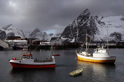 Sailboats on snowcapped mountains against sky during winter