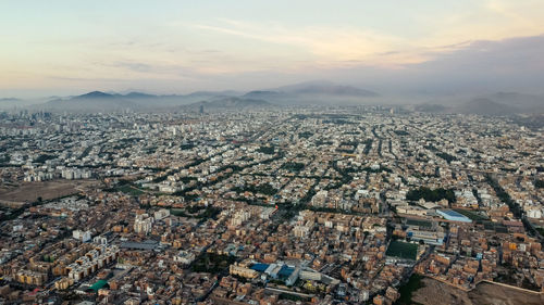 High angle view of illuminated cityscape against sky during sunset