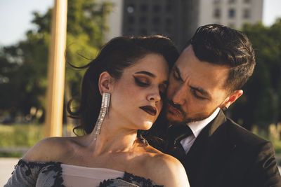 Midsection of couple kissing in park