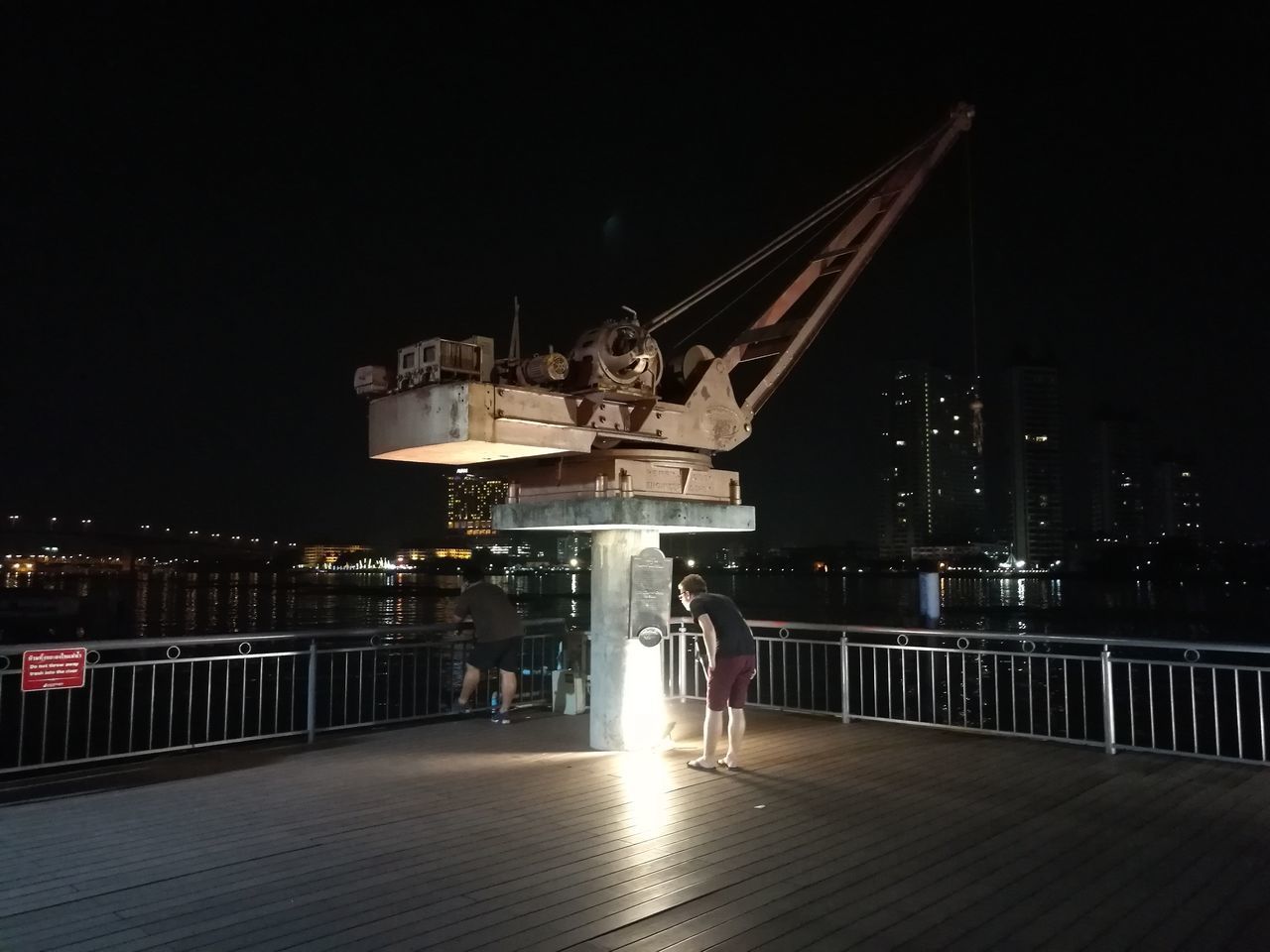 ILLUMINATED PIER OVER CITY AT NIGHT