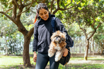 Young woman holding dog at park