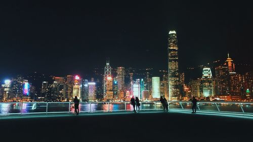 Illuminated buildings against sky at night