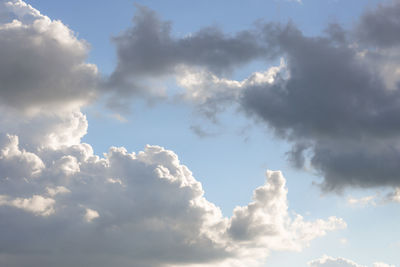 Low angle view of sunlight streaming through clouds