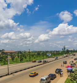 Cars on street in city against sky