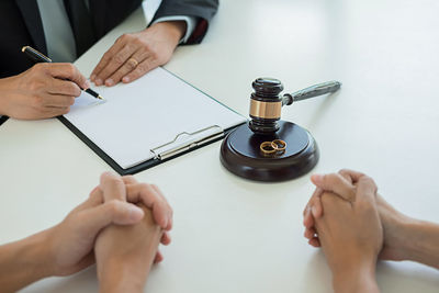 Midsection of man holding book with text on table