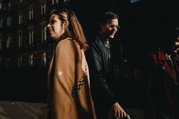 SIDE VIEW OF YOUNG COUPLE LOOKING AT NIGHT