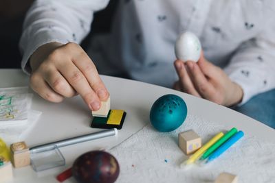 Midsection of woman decorating easter egg