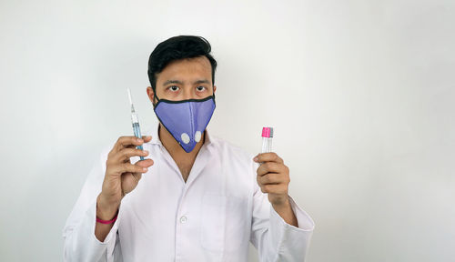 Portrait of man standing against white background