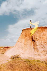 Low angle view of woman standing on rock