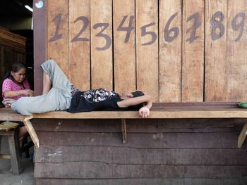 Rear view of man sleeping in front of church