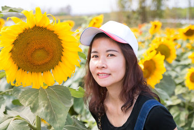 Portrait of beautiful woman against yellow flowers