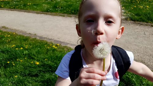 Portrait of cute girl holding grass