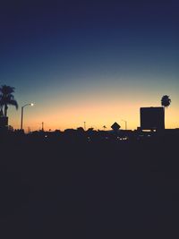 Silhouette city against clear sky at dusk