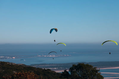 Low angle view of person paragliding against sky