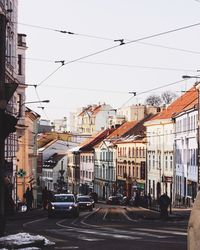 Cars on street in city against sky