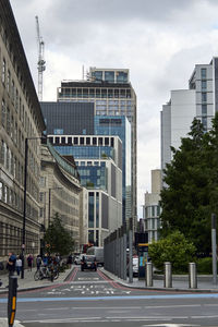 View of city street against cloudy sky