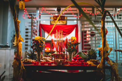 Illuminated candles on table at temple