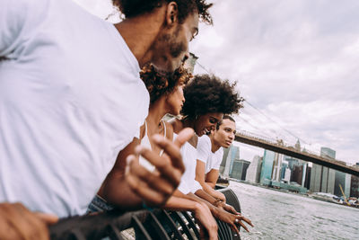 Midsection of couple holding hands against sky