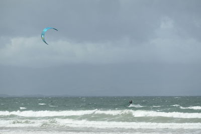 People in sea against sky