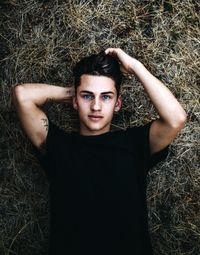 Directly above portrait of man lying on hay