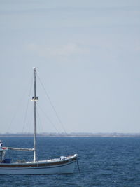 Sailboat sailing on sea against sky