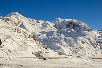 Low angle view of snowcapped mountains on sunny day