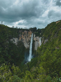 Scenic view of waterfall against sky