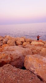 Scenic view of rocks in sea against sky during sunset