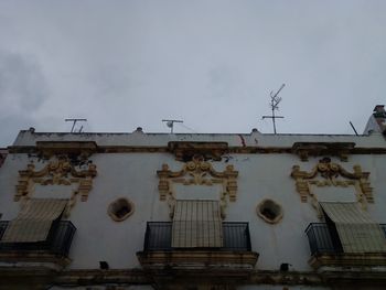 Low angle view of text on building against sky