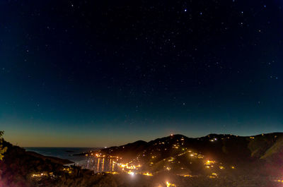 Scenic view of illuminated mountains against sky at night