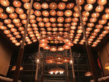 Low angle view of illuminated light bulbs hanging from ceiling