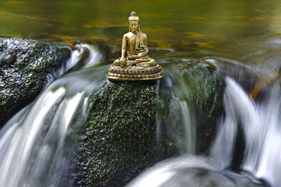 Buddha sculpture in flowing water