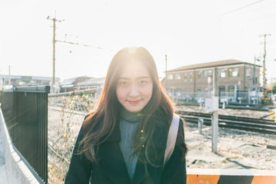 Portrait of smiling young woman standing on road